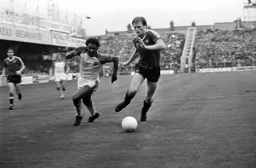 Ricky Hill gets round Gordon McQueen