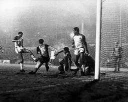 The ball goes through a sea of legs as Clive Goodyear`s goal is on its way