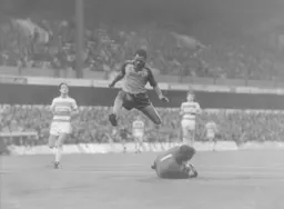 Brian Stein leaps over Q.P.R. keeper Peter Hucker who safely gathers the ball