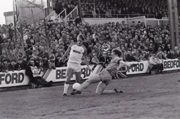 Paul Walsh takes on the defender