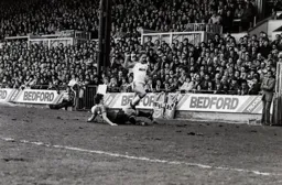 Paul Walsh tries to jump over Kevin Moran
