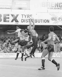 Gary Bailey makes a safe catch under pressure from Ricky Hill