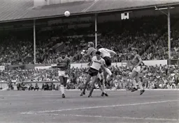 Ian Andrews punches the ball away from Mike Newell and Steve Foster