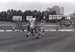 Ashley Grimes heads the ball forward looking to find Mike Newell