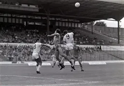 Mike Newell challenges for a high ball watched by Brian Stein