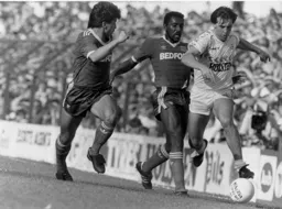 Tony Galvin forces his way past Ricky Hill