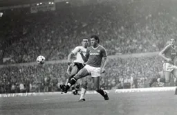 Paul McGrath clears the ball away from Brian Stein