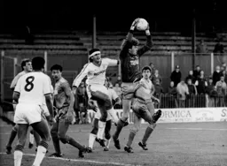 Wimbledon keeper Dave Beasant safely catches the ball under pressure from Steve Foster