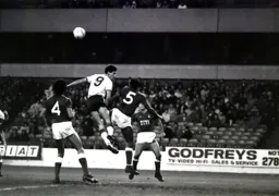 Mike Newell gets up high but Chris Fairclough heads the ball clear