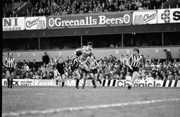 Mike Newell takes a shot at goal despite Kenny Wharton's attempts to block it