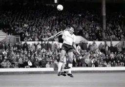 Mick Harford wins a header despite former Hatter Paul Elliott`s challenge