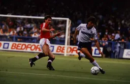 Mal Donaghy brings the ball away from Brian McClair