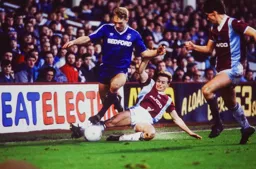 Tim Breacker rides a tackle by Mark Ward