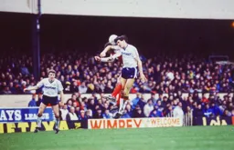 Mick Harford goes up for a heading duel watched by Danny Wilson