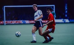 Tim Breacker plays the ball away from Steve Hodge