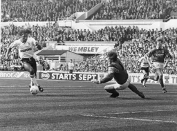 Ricky Hill takes the ball around Steve Sutton