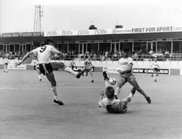 Trevor Putney goes to ground to block a shot by Mick Harford