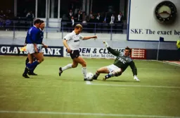 Tim Breacker rounds Neville Southall