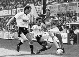 Kingsley Black going past two Derby defenders