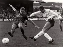 Lars Elstrup shoots as Geoff Thomas lunges in