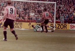 Alec Chamberlain saves at the feet of Ian Bryson