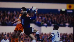 Mick Harford challenges the keeper