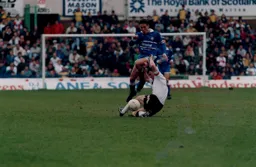 Paul Telfer hurdles a Derby defender