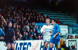 The linesman points his flag as Kerry Dixon looks on