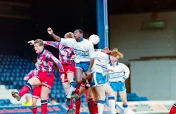 Mitchell Thomas and John Hartson challenge for the ball