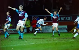 Scott Oakes wheels away after scoring the first goal while Wesat Ham appeal for offside