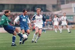 Kasey Keller clears the ball from an onrushing Kerry Dixon