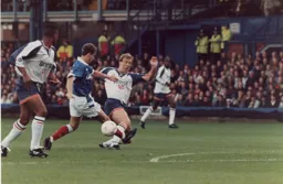 Kerry Dixon manages to clip the ball through to Dwight Marshall