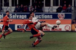 Wayne Biggins tries to lob the goalkeeper
