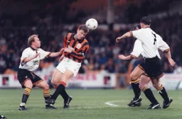 Steve Davis is surrounded but still gets his head to the ball