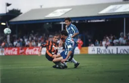 Simon Davies is tackled by David Gregory. Future Town manager Paul Buckle is in on the action too