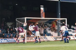 Oldham keeper Mike Pollitt gathers the ball under pressure from Mitchell Thomas