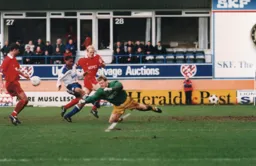 Martin Taylor punches the ball away from an onrushing Dwight Marshall