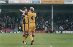 Town fans celebrate in the background after the first goal