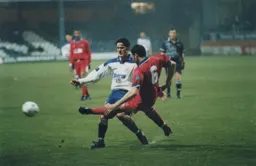 The outstretched leg of Darren Carr blocks Rory Allen