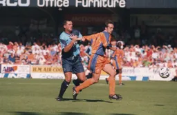 Ray McKinnon holds off the challenage of a Wycombe player