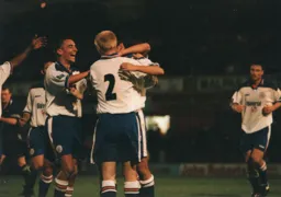Ray McKinnon surrounded by teammates in celebration