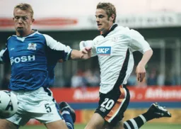 Peter Holmes and Simon Rea fight for the ball