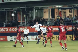Andy Tillson heads the ball clear from a leaping Peter Thomson