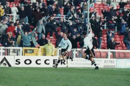 Keith Rowland wheels away after scoring in front of happy travelling supporters
