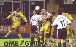 Steve Howard and Russ Perrett battle in the air with the Mansfield players