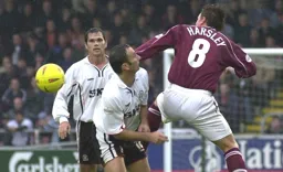 Ahmet Brkovic in action as Aaron Skelton looks on