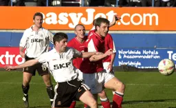 Steve Howard watches Tony Thorpe battling for the ball