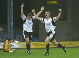 Kevin Foley and Steve Howard with arms raised celebrate Foley`s goal