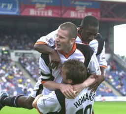 Kevin Nicholls and Courtney Pitt share their delight after Steve Howard`s goal