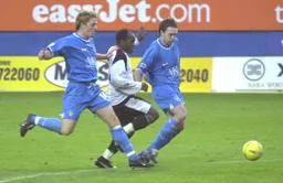 Adrian Forbes forces his way through two defenders